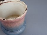 a blue and pink vase sitting on a table