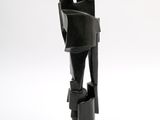 black sculpture of a hand holding a gun on a white surface