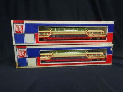 two boxes of toy trains sitting on a black surface