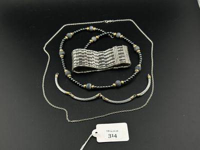 deux colliers et un bracelet posés sur une table, accompagnés d'une étiquette de prix