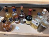 many bottles of alcohol sitting in a wooden drawer