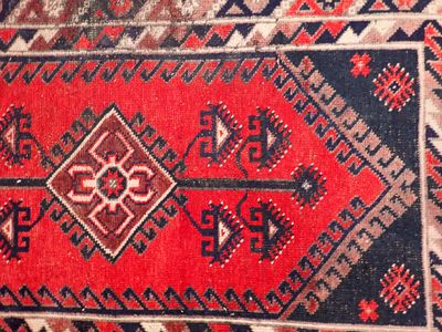 un gros plan sur un tapis rouge et bleu orné d'un motif