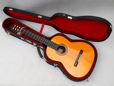 une guitare dans un étui, posée sur une surface blanche