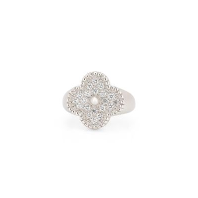 un gros plan d'une bague ornée d'une fleur en diamant sur fond blanc
