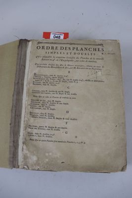 un vieux livre ouvert sur une table blanche