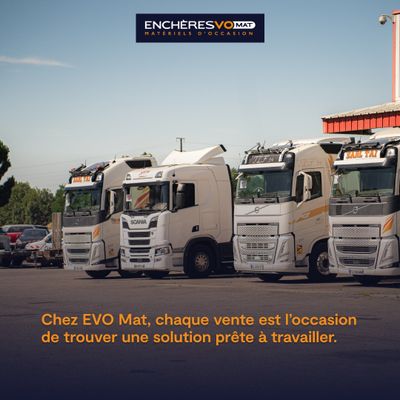 four trucks parked in a parking lot with a building in the background
