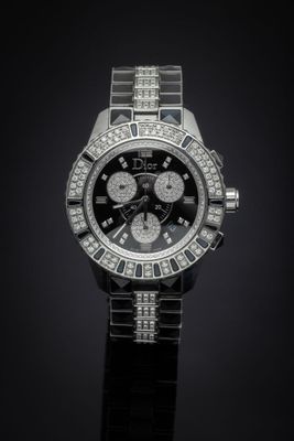 a close up of a watch on a black surface with a black background