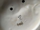 a close up of a white vase with a face on it
