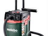 a green and red vacuum cleaner with a hose