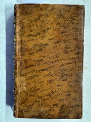 un vieux livre posé sur une table couverte de terre