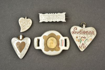 quatre bijoux en argent et en or posés sur un fond gris