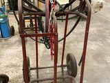 un petit chariot muni d'un tuyau, dans un garage