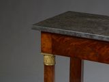 a small table with a marble top and wooden legs