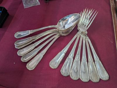a lot of silver spoons and forks on a table