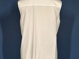 a white shirt on a mannequin stand against a blue wall