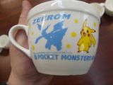 a person holding a coffee cup with a pokemon design on it