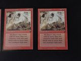 three cards are sitting on top of a table with a black background