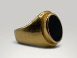 a close up of a gold ring with a black stone in it