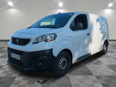 une camionnette blanche garée dans une pièce au sol en damier