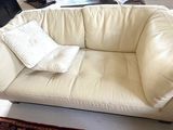 a white couch with two pillows on it in a living room