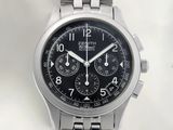 a close up of a watch on a white surface with a black dial