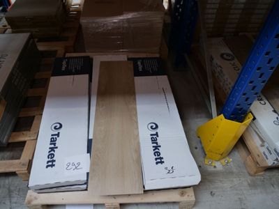 une palette remplie de cartons posée à même le sol dans un entrepôt