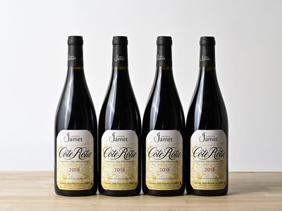 trois bouteilles de vin sont alignées sur une table en bois