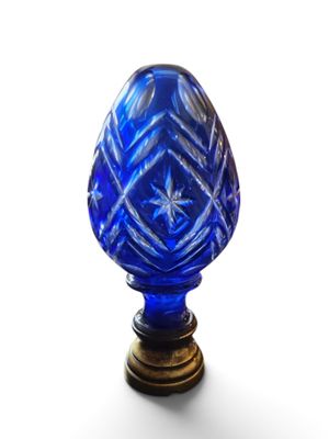 an image of a blue glass vase sitting on top of a wooden stand
