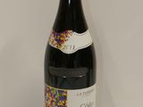 the bottle of wine is sitting on the table next to the wall