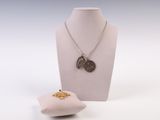 un collier et un oreiller posés sur un présentoir pour mannequin