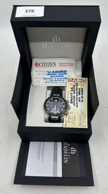 une montre dans une boîte contenant un ticket