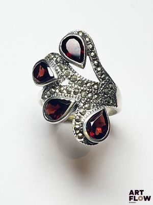 une image représentant une bague sertie de grenats sur un fond blanc