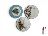 three plates with different designs on them on a white surface