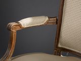 a close up of a wooden chair with a beige upholstered seat