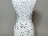 a white mannequin with black and white drawings on it