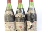 trois bouteilles de vin posées les unes à côté des autres sur une surface blanche