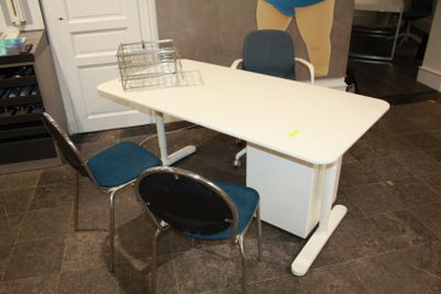 un bureau blanc avec une chaise bleue, et une chaise bleue placée devant celui-ci