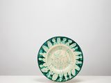 une assiette verte et blanche posée sur une table blanche