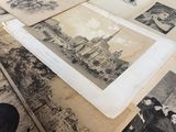 de nombreuses vieilles photos posées sur une table, à côté d'une paire de ciseaux
