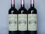 three bottles of red wine sitting on a table next to each other
