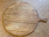 une planche à découper en bois posée sur le sol d'une cuisine
