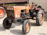 un vieux tracteur garé devant un bâtiment