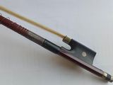an image of a violin bow with a wooden handle on a white surface
