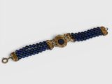 a close up of a blue beaded bracelet with a gold clasp