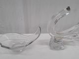paire de plats en verre transparent en forme de cygne posés sur un support blanc