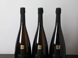 three bottles of wine sitting on a table next to each other