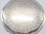 a silver plate on a white surface with a silver handle
