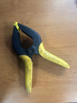 une pince jaune et noire posée sur une table en bois