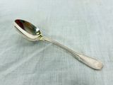 a silver spoon with a spoon handle on a table