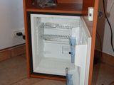 a small refrigerator in the corner of a kitchen